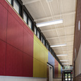 The mixture of primary red, blue, and yellow colored panels in the hallway of Ogden Elementary School break up the space and create a stimulating effect for children.